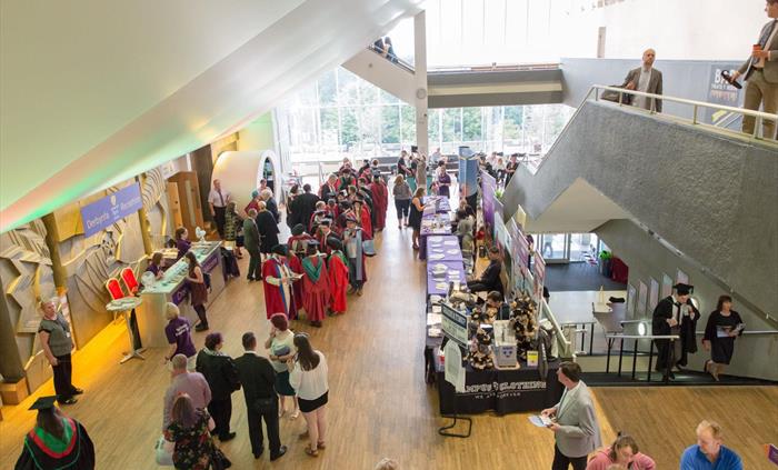 A busy foyer space with large windows and information desks